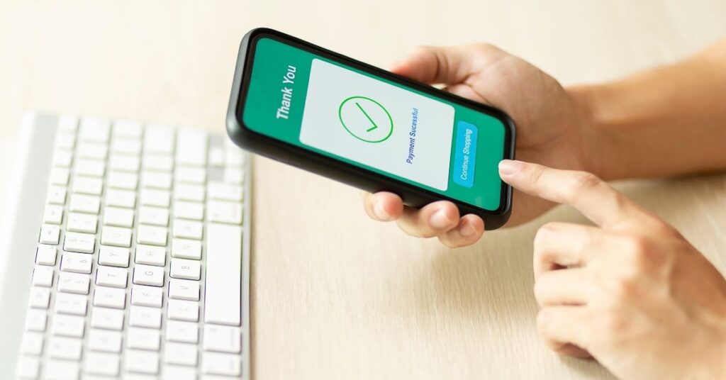 A woman successfully makes a payment on her mobile phone.