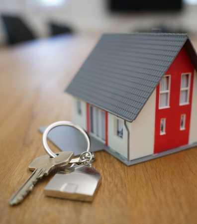 House keys next to a miniature model house.
