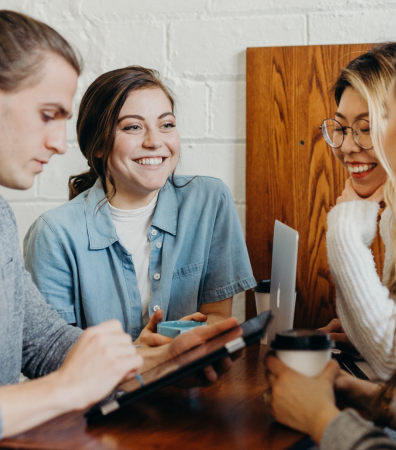 Three people smiling as they use their devices.