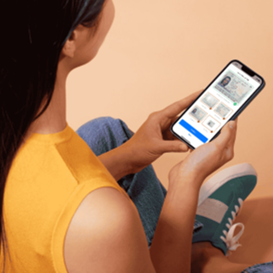 A woman looks at her ID verification on her phone app.