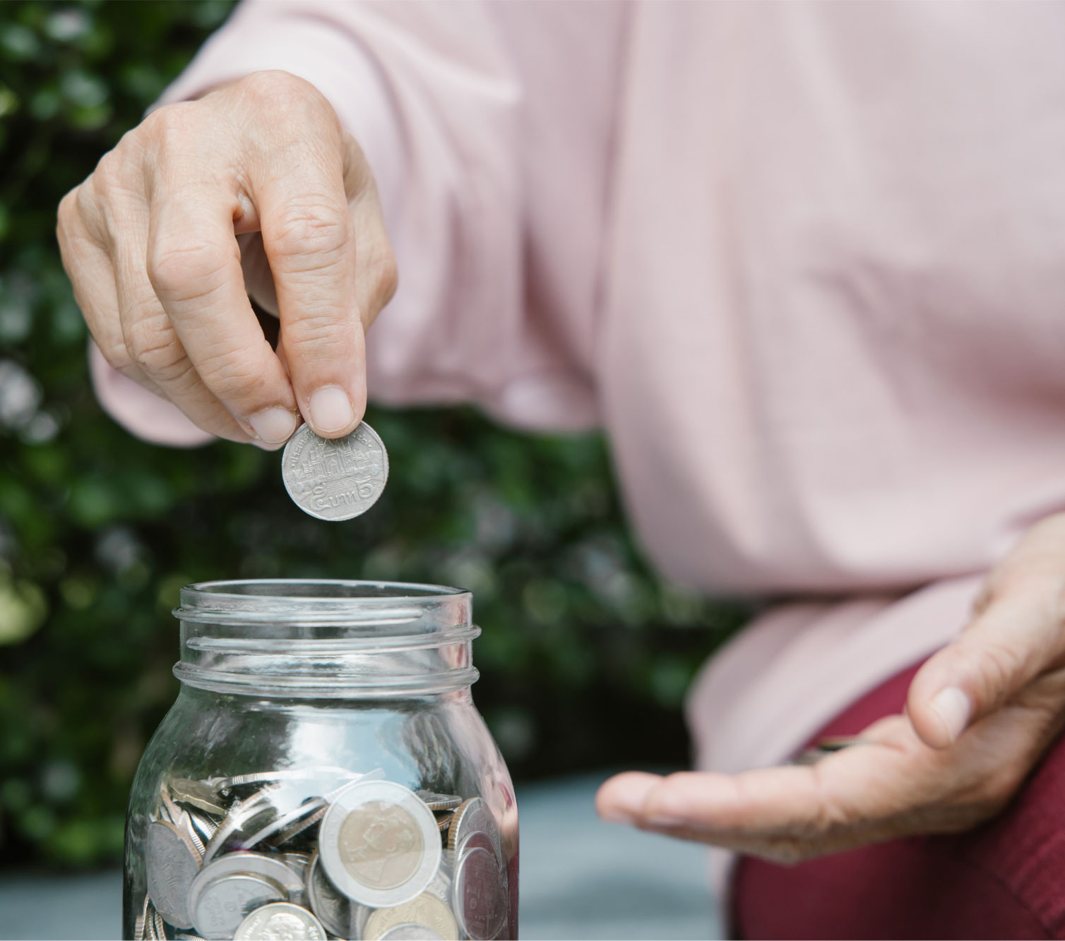 Someone putting change into a coin jar.