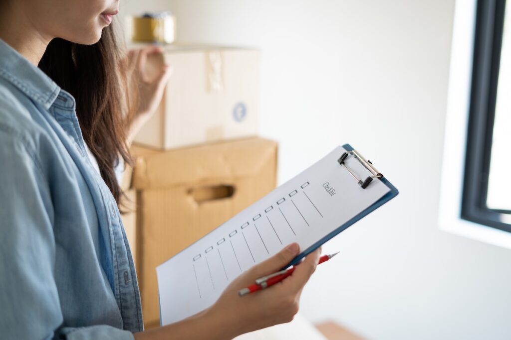 A woman looks at a checklist on a clipboard.