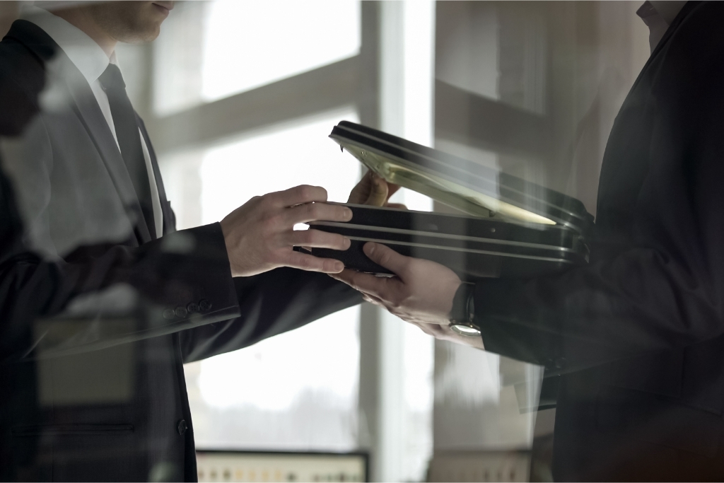 Two businessmen open a spooky briefcase – implying dodgy deals